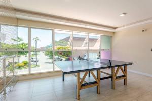 a table in a room with a large window at Apto 1 quarto no Golden Lake! in Arraial do Cabo