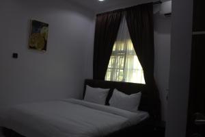 a bed in a room with a window and a bed sidx sidx sidx at The Vistana 4Bedroom Pearly Gate Estate Ikota VGC Lekki in Igboshere