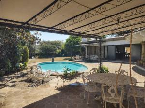 un patio con tavolo, sedie e piscina di Residencia Casa del Roble 1 a Cuernavaca