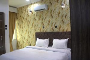 a bedroom with a white bed with a wall with a wall mounted heater at The Vistana 4Bedroom Pearly Gate Estate Ikota VGC Lekki in Igboshere