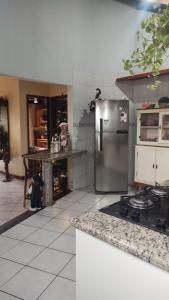 a kitchen with a stainless steel refrigerator and a counter at Quarto da Tati in Garopaba