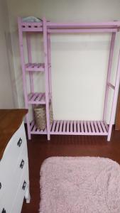 a pink bunk bed in a room with a rug at Quarto da Tati in Garopaba