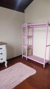 a pink bunk bed in a room with a rug at Quarto da Tati in Garopaba