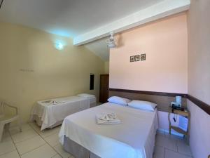 a room with two beds with white sheets at Big Valley Hotel Fazenda in Serra Negra +65 photos