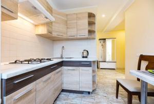 a kitchen with wooden cabinets and a sink and a stove at Апартаменти Дарницька площа in Kyiv +9 photos