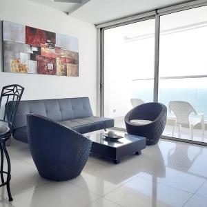 ein Wohnzimmer mit Sofa, Stühlen und einem Tisch in der Unterkunft Lodging Apartamento 1 Frente a la Playa in Cartagena de Indias