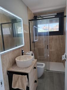 a bathroom with a sink and a shower and a toilet at Chalet de lujo con piscina cercano a la playa in Nigrán