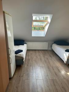 a small room with two beds and a window at Apartamenty Ścinawa in Ścinawa +39 photos
