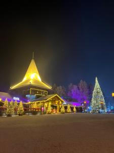 a building decorated with christmas trees and lights at night at Cozy and modern apartment with lakeside view in Rovaniemi