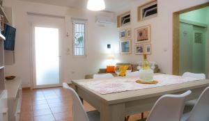a dining room with a table and white chairs at La Casa al Mare di Manu in Torre San Gennaro
