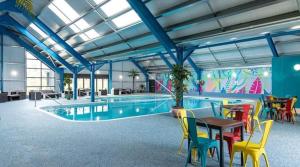 a pool with a table and chairs and a table and a tablektop at Marie Helene, 58 Mallard Carlton Meres Holiday Park in Kelsale