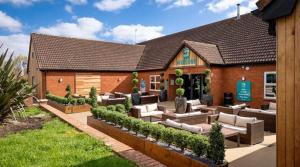 a building with couches and chairs in a yard at Marie Helene, 58 Mallard Carlton Meres Holiday Park in Kelsale