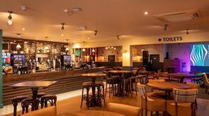 a bar with tables and stools in a restaurant at Marie Helene, 58 Mallard Carlton Meres Holiday Park in Kelsale