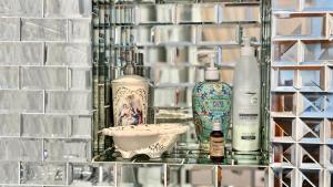 - une étagère en verre avec des bouteilles et un bol dans l'établissement FSF Boutique Apartament, à Timişoara 46 autres photos