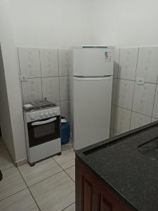 een keuken met een koelkast en een fornuis bij Chalé do corisco in Paraty