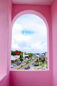 a pink window with a view of a street at Hotel Rosa del Alba, Barrio Mágico Centro Histórico de Chetumal in Chetumal