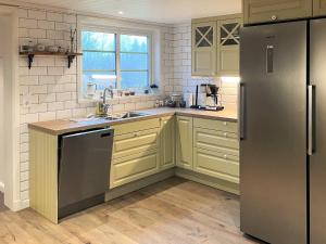 a kitchen with yellow cabinets and a stainless steel refrigerator at 4 star holiday home in KARLSKRONA in Karlskrona +27 photos