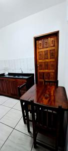 een houten tafel met 2 stoelen en een houten deur bij Chalé do corisco in Paraty +8 foto's