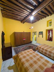 two beds in a room with yellow walls at Beit Melhem in Zahlé +38 photos