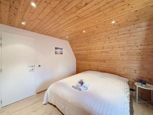 a bedroom with a white bed with a wooden ceiling at Villa Zonnedauw - Koksijde in Koksijde