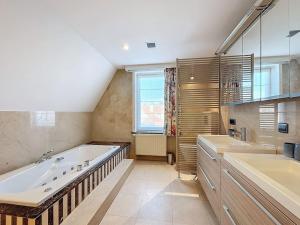 a large bathroom with a tub and two sinks at Villa Zonnedauw - Koksijde in Koksijde +29 photos