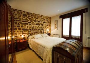 Un dormitorio con una cama y una pared de piedra. en El Rincón del Tarabilla, en Fermoselle