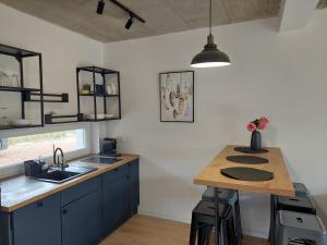 a kitchen with blue cabinets and a wooden counter top at Domki Granero w Górach Sowich in Grzmiąca