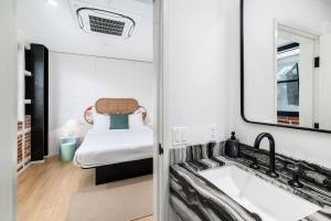 a bathroom with a sink and a bed at The Brick Boutique Hotel in Oceanside +37 photos