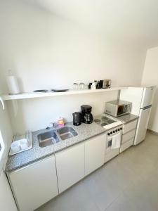 a kitchen with a sink and a stove and a refrigerator at Saavedra 118 1°H by depptö in Bahía Blanca +2 photos