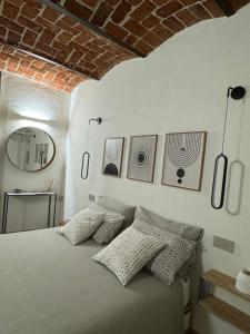 una camera da letto con letto con cuscini e parete in mattoni di Le Corti a Cuneo