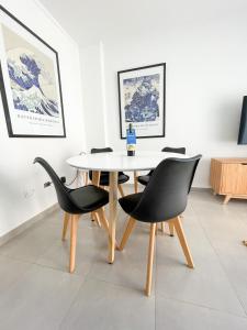 a dining room with a white table and chairs at Saavedra 118 1°H by depptö in Bahía Blanca