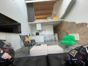 a living room with a couch and a green chair at Corazón Casco Viejo Ático in Vigo