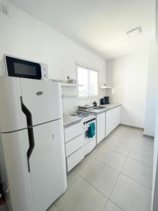 a white kitchen with a refrigerator and a sink at Saavedra 118 1I by depptö in Bahía Blanca