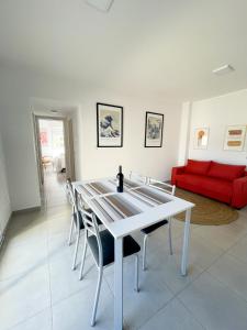 a white dining room with a white table and chairs at Saavedra 118 1I by depptö in Bahía Blanca