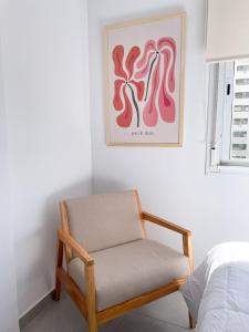 a chair sitting in a room next to a bed at Saavedra 118 1I by depptö in Bahía Blanca