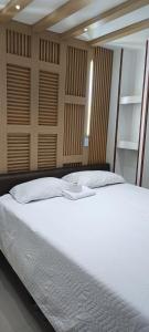 a bedroom with a large bed with white sheets at EstanciaS ALELI norte Vipasa entr salida aerprto terml de tte base aérea MFS C eventos valle del Pacífic orquideorama in Cali