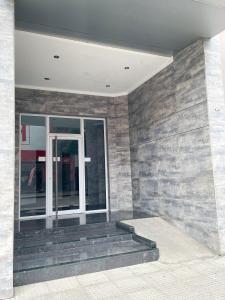 a lobby with a stone wall and stairs in front of a building at Saavedra 118 1°H by depptö in Bahía Blanca