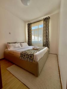 a bedroom with a large bed and a window at Best homes apartments near JKIA in Nairobi