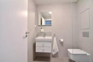 a white bathroom with a toilet and a sink at BRIS Apartment, 1-2 guests, Free Parking & Wifi, 4km Downtown, Bratislava in Nivy
