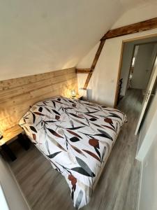 una camera da letto con un letto e una coperta per mucche di Les grumeaux Colmar Est a Horbourg