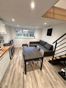 una cucina e un soggiorno con un tavolo e un divano di Les grumeaux Colmar Est a Horbourg