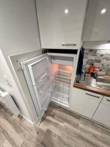 un frigorifero vuoto con la porta aperta in una cucina di Les grumeaux Colmar Est a Horbourg Altre 11 foto
