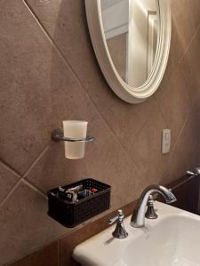 a bathroom sink with a mirror and a basket of tools at Gente del Sur - Gobernador Paz in Ushuaia +120 photos