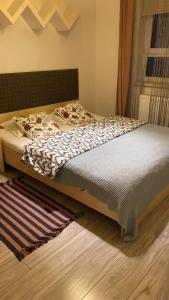 1 cama en un dormitorio con alfombra en el suelo en Apartament Stanczyka 2, en Varsovia