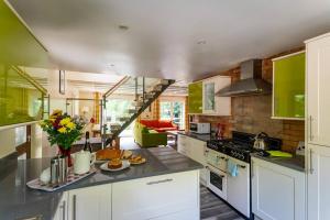 a large kitchen with white cabinets and green at Ellastone, woodland lodge with hot tub for 8 in Oakamoor