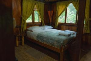 a bedroom with a bed in a room with windows at Finca Las Palmas Ecolodge in Puyo +74 photos