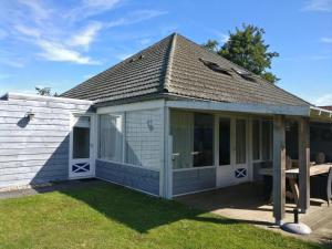 una casa blanca con una mesa de picnic en el patio en Duinroos Home with Terrace, en Breskens