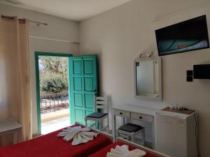 a bedroom with a bed and a desk and a mirror at Dimitris Villa Hotel in Matala