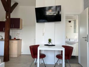 a kitchen with a white table and two red chairs at Marktplatzapartment in Höxter