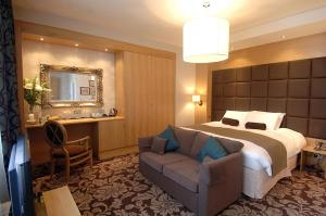 una habitación de hotel con una cama grande y una silla en The Briar Rose Wetherspoon en Birmingham